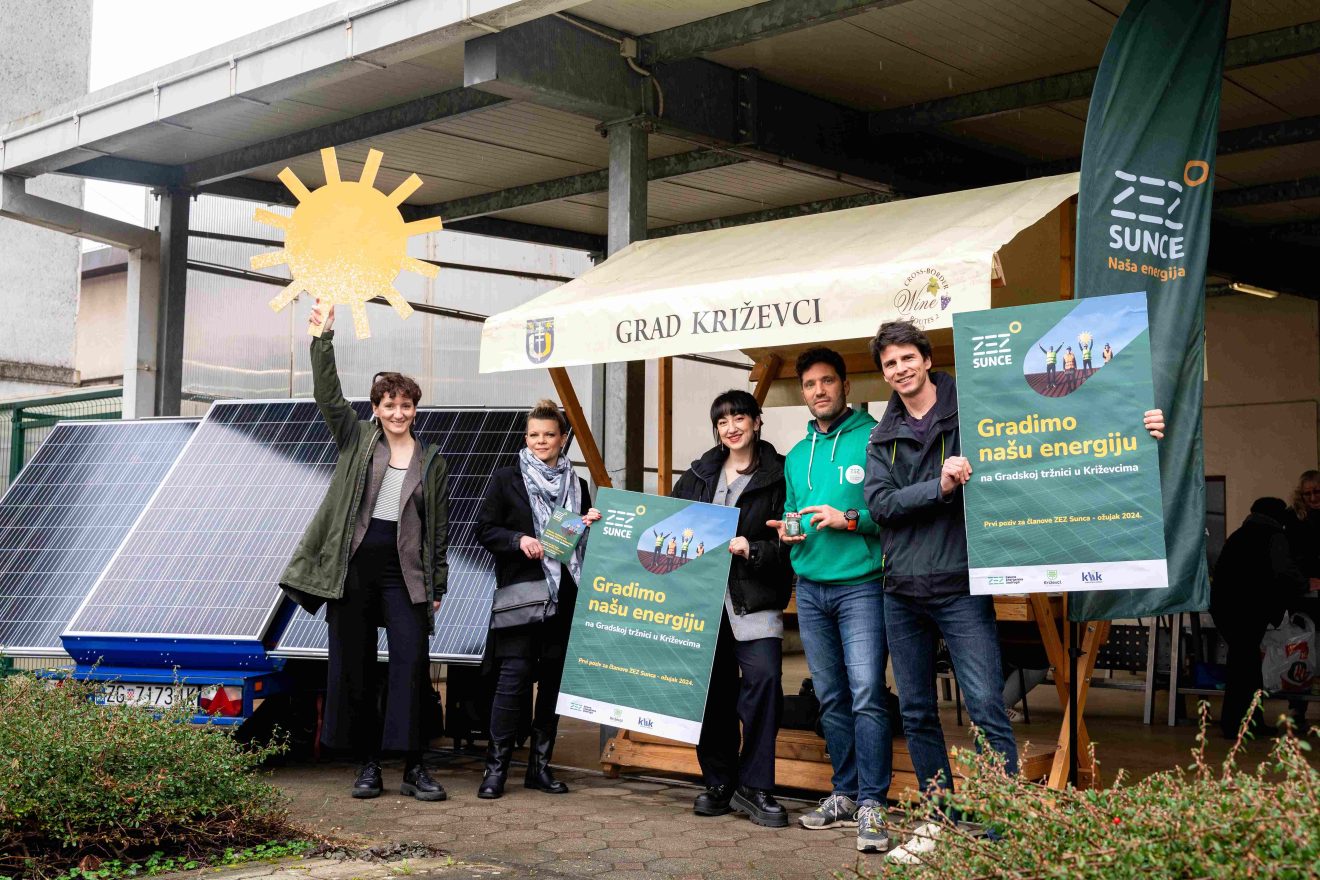 personnes tenant des panneaux devant des panneaux solaires